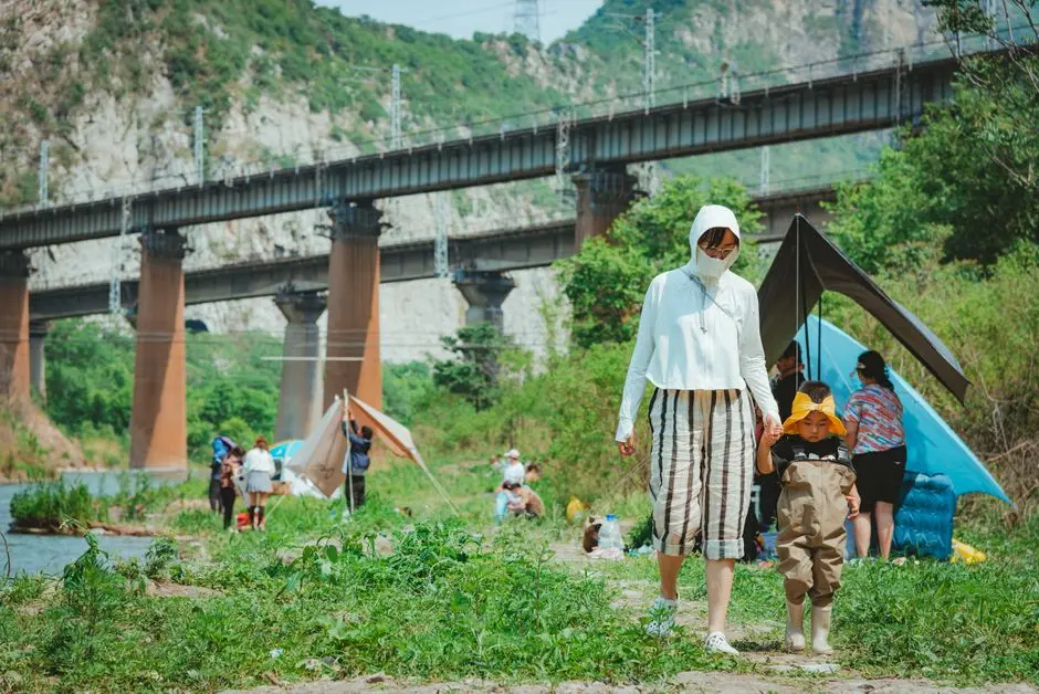 Keluarga sedang piknik di tepi waduk, anak-anak bermain air